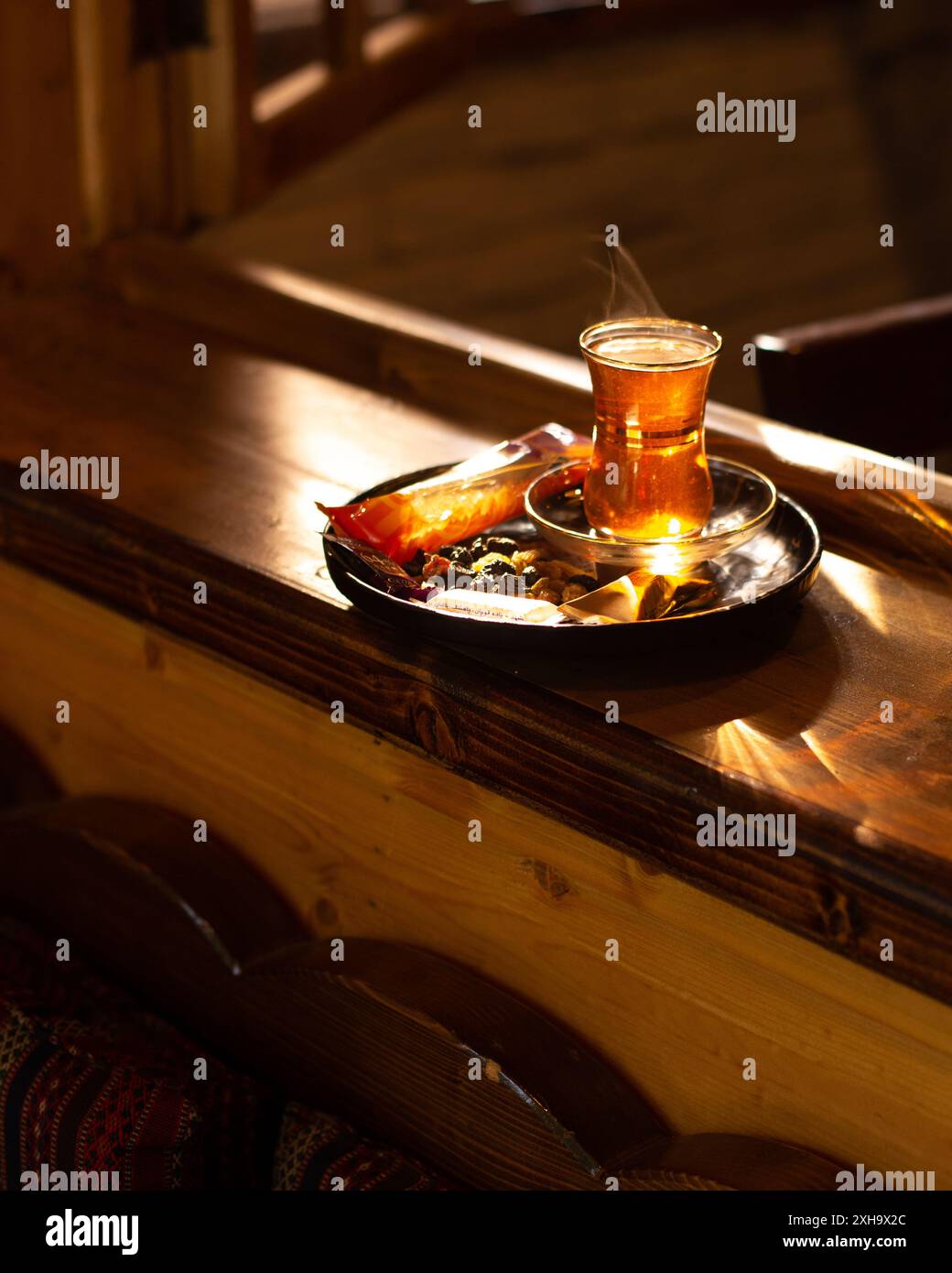 Goditi una tazza calda di tè persiano con una selezione di noci e dolci, che riflettono l'ospitalità iraniana Foto Stock