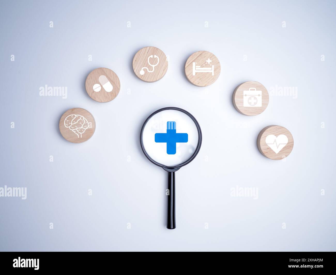 Una lente d'ingrandimento si concentra sul segno più e sull'icona medica sanitaria su sfondo bianco, concetto di assicurazione sanitaria, salute e accesso alla guarigione del benessere Foto Stock