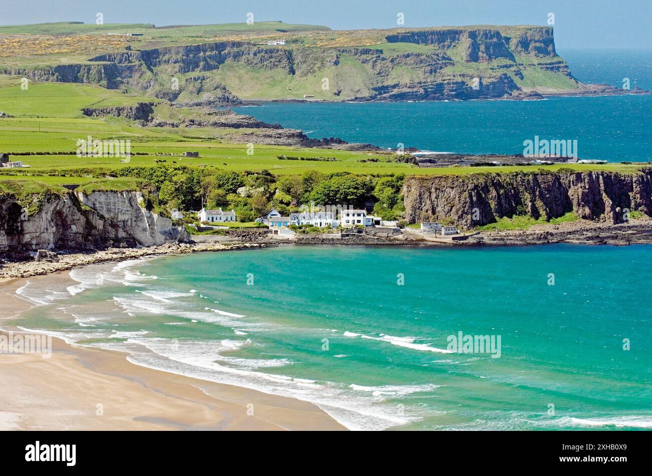 White Park Bay su giganti Causeway costa della contea di Antrim, Irlanda. Guardando al villaggio Portbraddon e la Causeway capezzagne Foto Stock