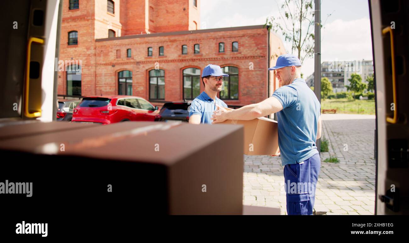 Scatole di carico e scarico efficienti per corrieri per il servizio di consegna espresso, che lavorano insieme con professionalità e lavoro di squadra per il successo. Foto Stock