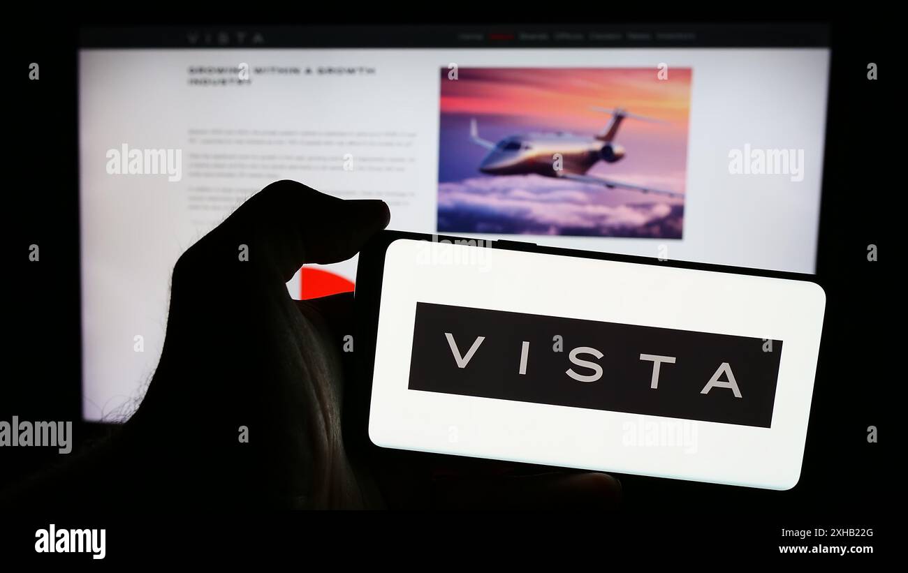 Persona che possiede un telefono cellulare con il logo della società aeronautica degli Emirati Vista Global Holding Limited davanti alla pagina Web. Mettere a fuoco il display del telefono. Foto Stock