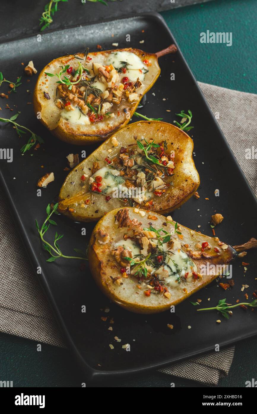 Pere al forno con formaggio blu, noci, miele e timo. Sana cucina francese Appetiser Foto Stock