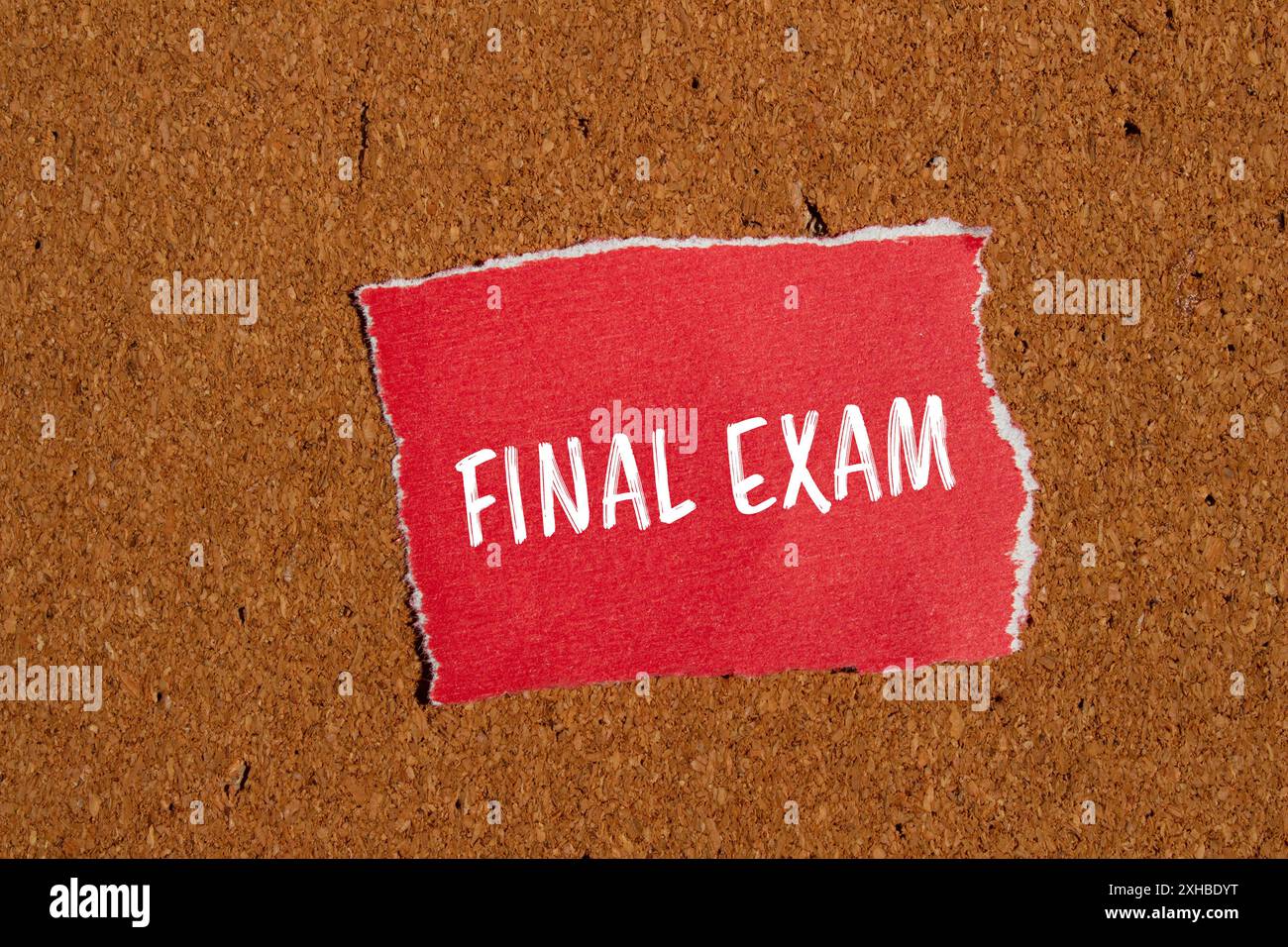 Parole dell'esame finale scritte su un pezzo di carta rosso strappato con sfondo marrone. Simbolo dell'esame finale concettuale. Copia spazio. Foto Stock