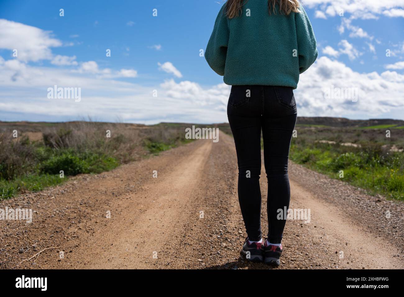 Donna all'inizio di un sentiero di sabbia. Inizio di nuovi percorsi e nuovi obiettivi Foto Stock