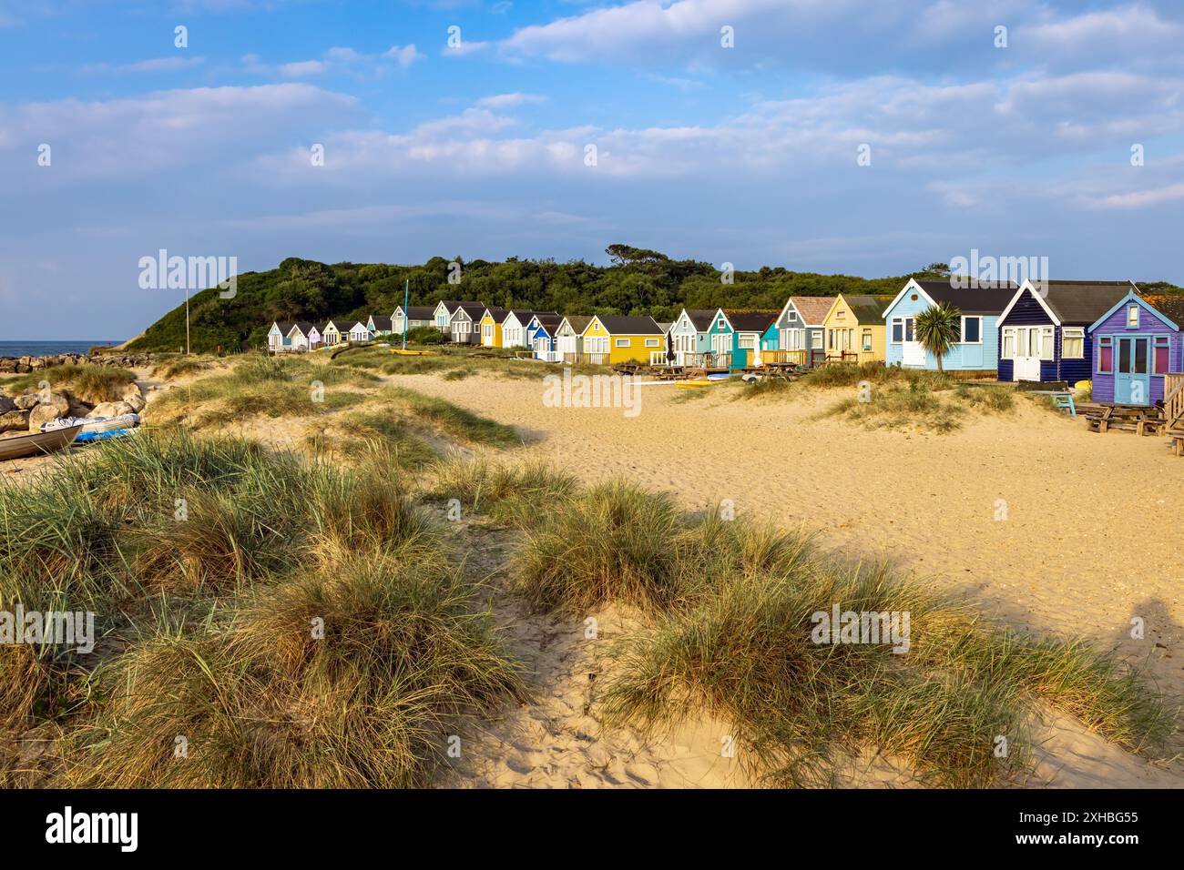 Vivaci rifugi sulla spiaggia di Mudeford Spit nel Dorset, Inghilterra. Le baite sulla spiaggia sono le più costose del Regno Unito. Foto Stock