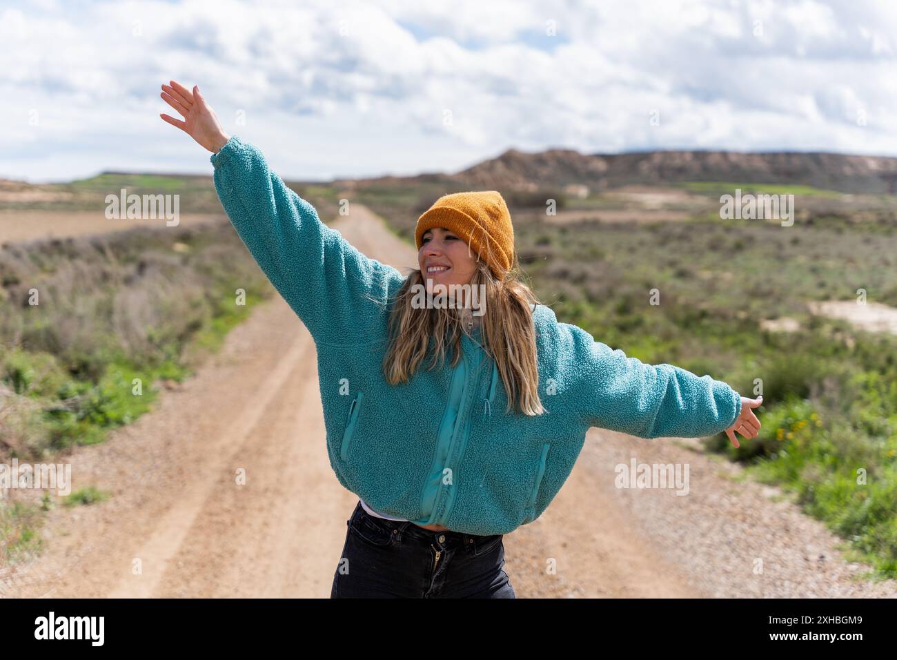 Donna sorridente e felice a braccia aperte sulla strada Foto Stock