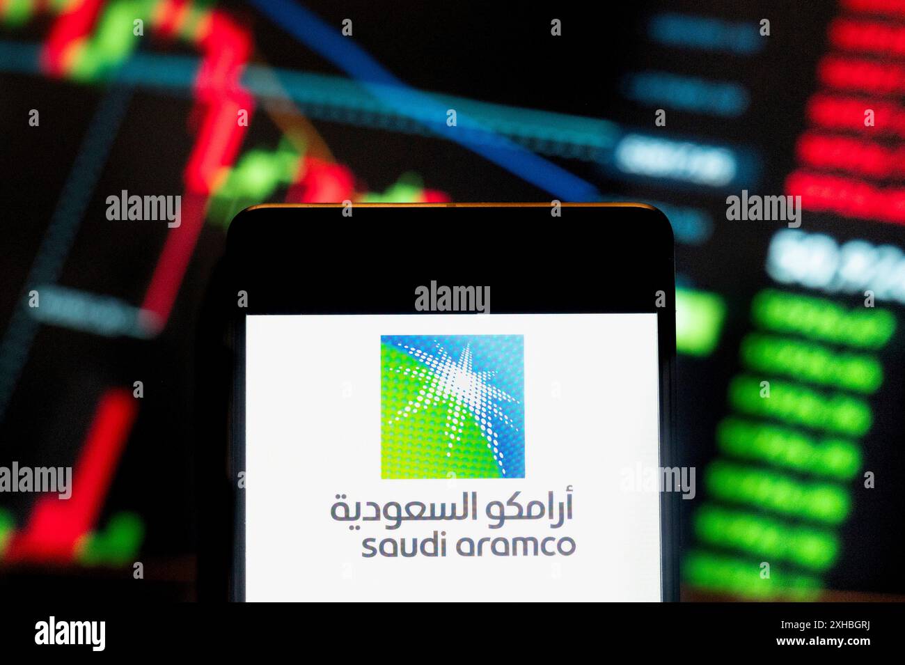 Cina. 21 giugno 2024. In questa immagine, il logo Saudi Arabian Oil Company, Saudi Aramco, è stato visualizzato su uno smartphone con un grafico dell'indice di borsa economica sullo sfondo. Credito: SOPA Images Limited/Alamy Live News Foto Stock