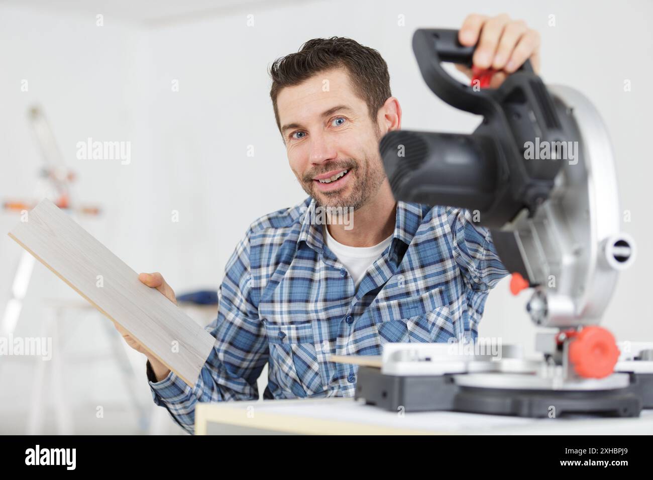 lavoratore dell'appaltatore che utilizza la sega circolare con azionamento a vite senza fine manuale Foto Stock