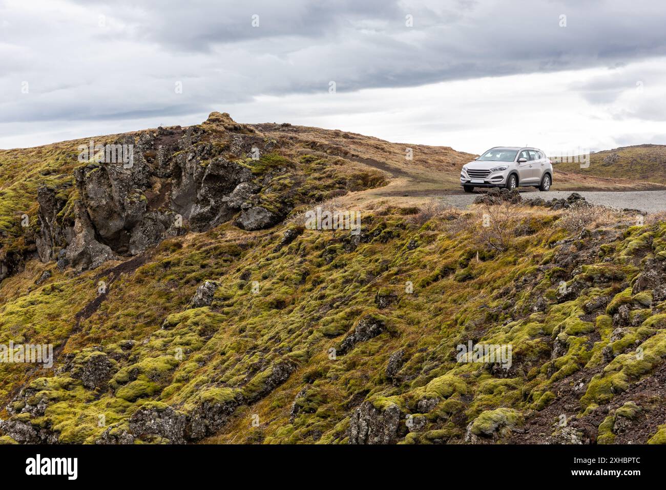 Auto fuoristrada parcheggiata ai margini della scogliera vulcanica ricoperta di muschio nel canyon di Gjain, valle di Thjorsardalur, Islanda meridionale. Foto Stock