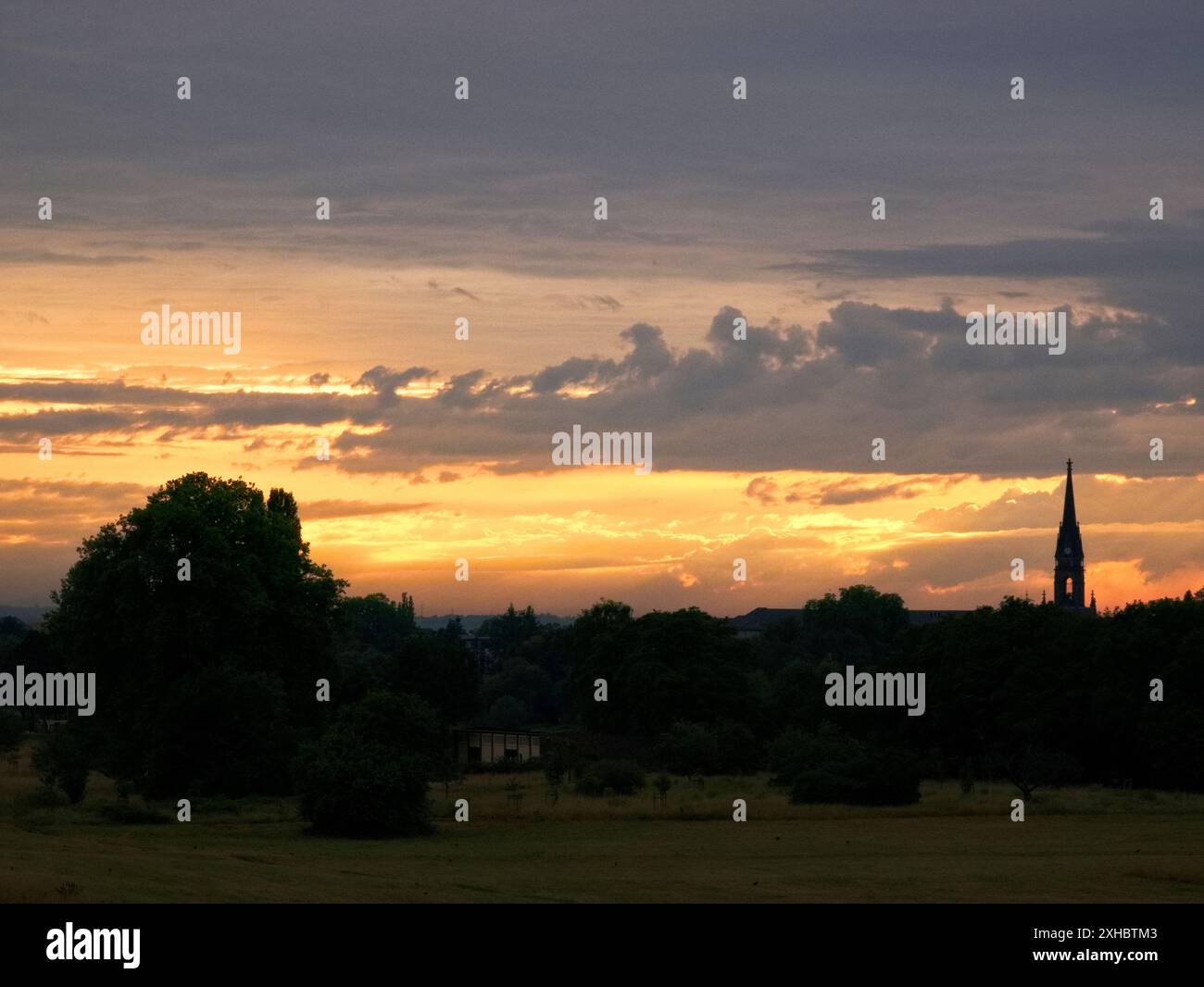 Un romantico tramonto si riflette nel fiume Elba. Sullo sfondo, lo skyline di Dresda con il Dreikönigskirche appare come una silhouette. Foto Stock