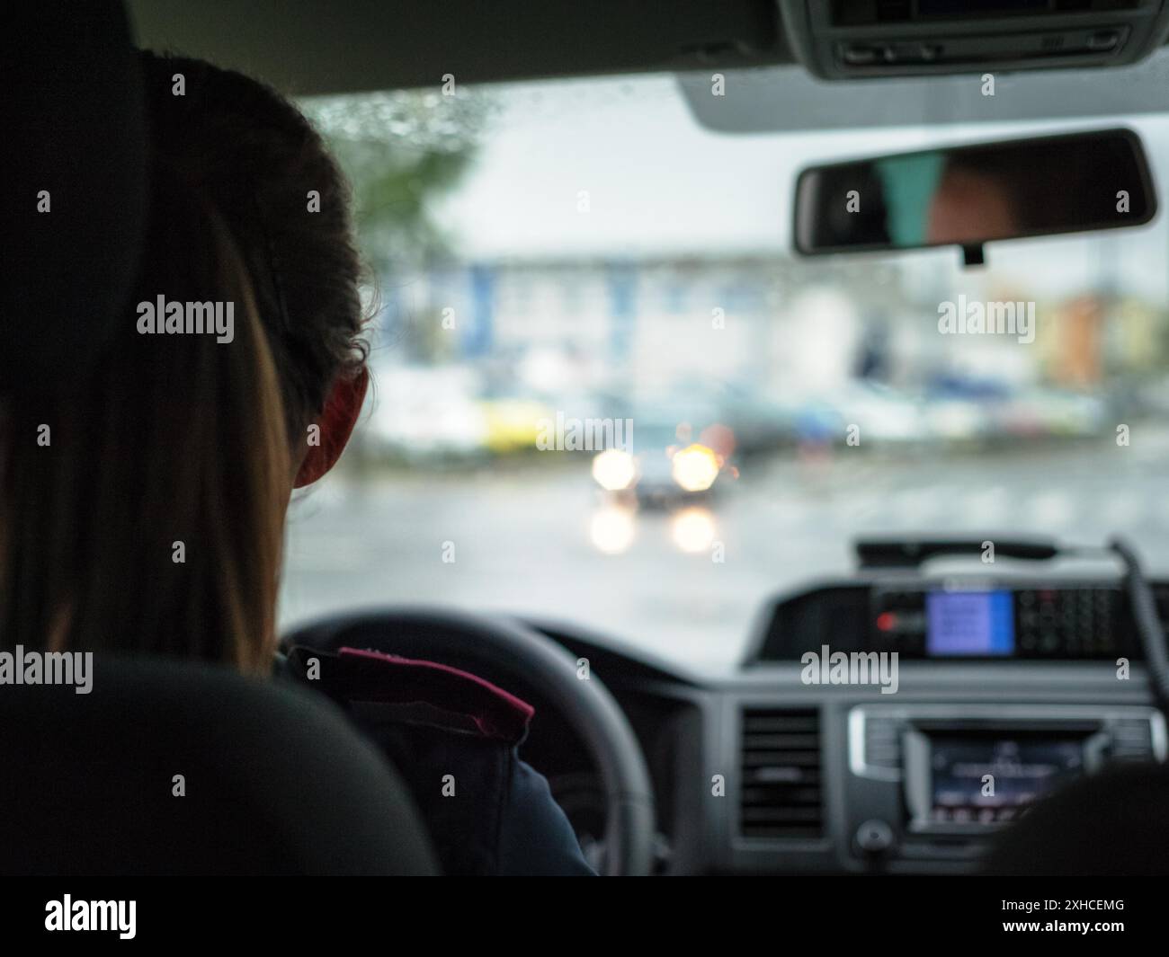 Donna che guida un'auto in città Foto Stock