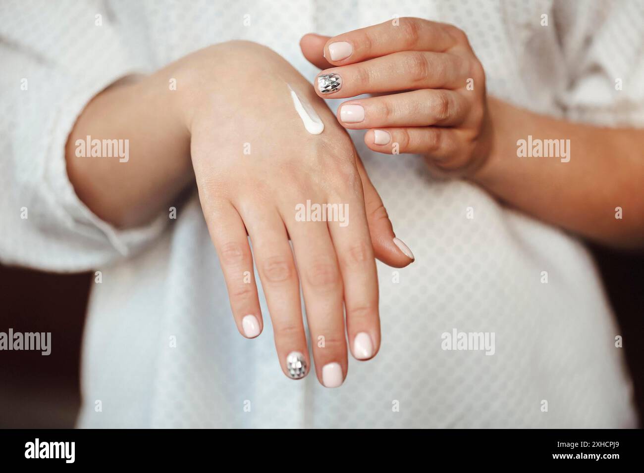 Crema di striscio femminile non riconoscibile sulle mani pulite durante la routine di cura della pelle a casa Foto Stock