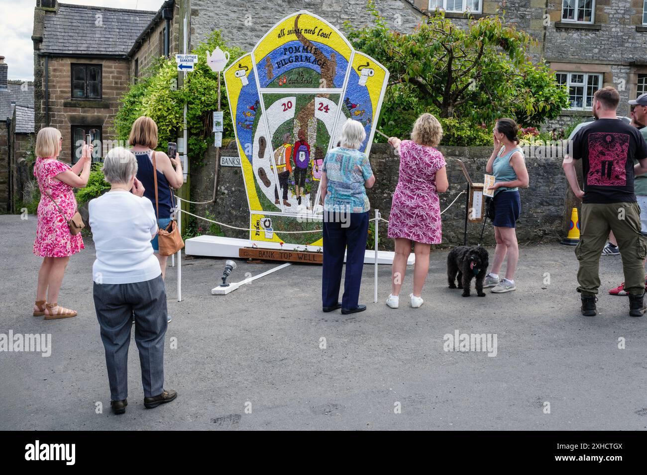 Visitatori che guardano il pozzo di Bank Top Well, Youlgrave, Peak District National Park, Derbyshire, 2024 Foto Stock