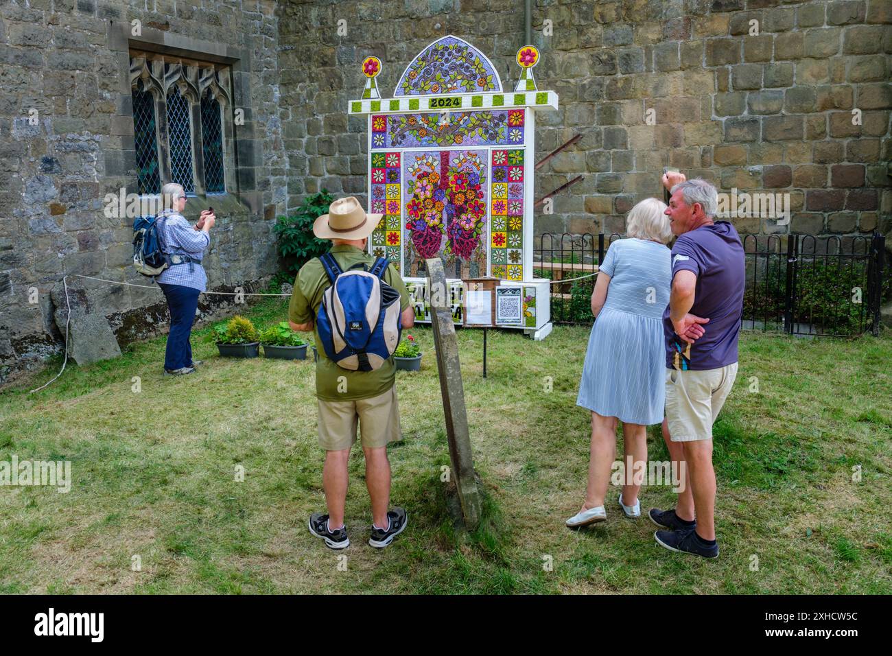 I visitatori che ammirano il pozzo di vestirsi al Reading Room Well, Youlgrave, Peak District National Park, Derbyshire, 2024 Foto Stock