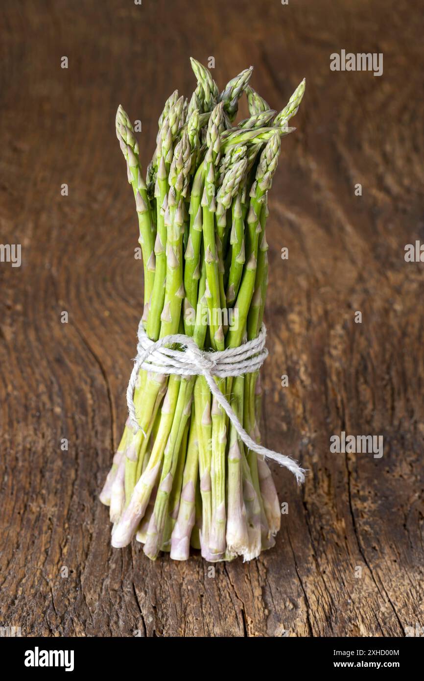 Asparagi verdi selvatici su legno Foto Stock