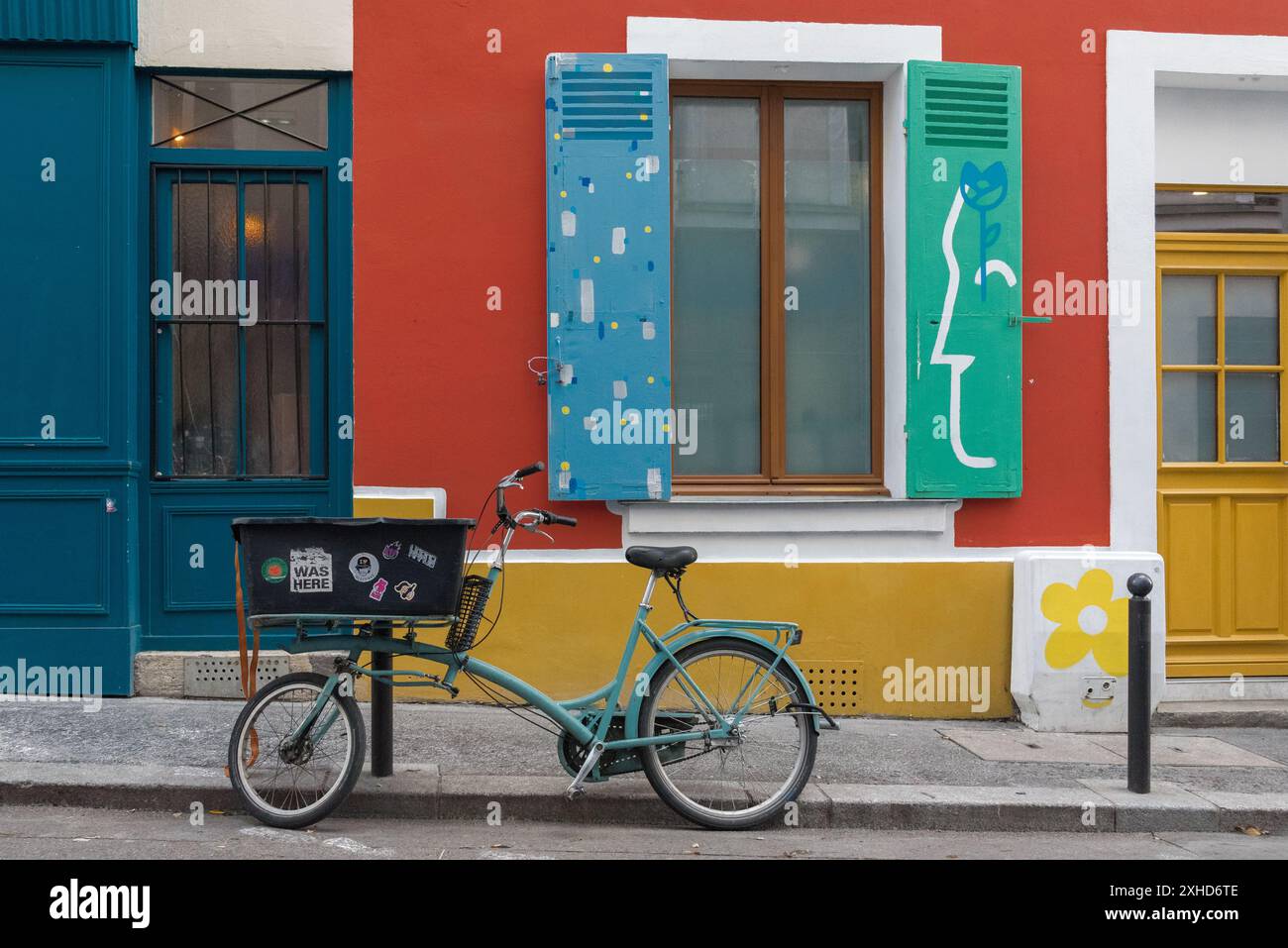 Biciclette parcheggiate di fronte alle case colorate in rue Sainte-Marthe, una piccola strada situata nel decimo arrondissement di Parigi, Francia. Foto Stock