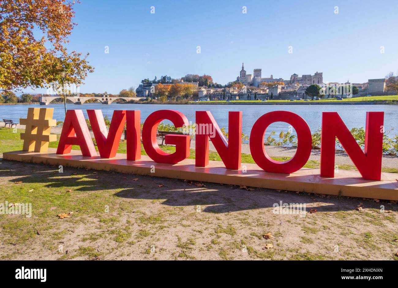 Avignone, Francia - novembre 25 2023: Avignone e il suo famoso ponte fotografati con lettere rosse del cartello di Avignone in primo piano. Papa medievale Foto Stock