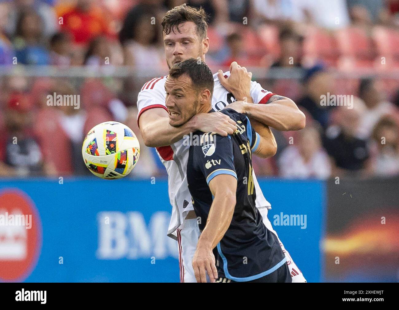 Toronto, Canada. 13 luglio 2024. Daniel Gazdag (davanti) del Philadelphia Union affronta Kevin Long del Toronto FC durante la partita di Major League Soccer (MLS) 2024 tra Toronto FC e Philadelphia Union al BMO Field di Toronto, Canada, il 13 luglio 2024. Crediti: Zou Zheng/Xinhua/Alamy Live News Foto Stock