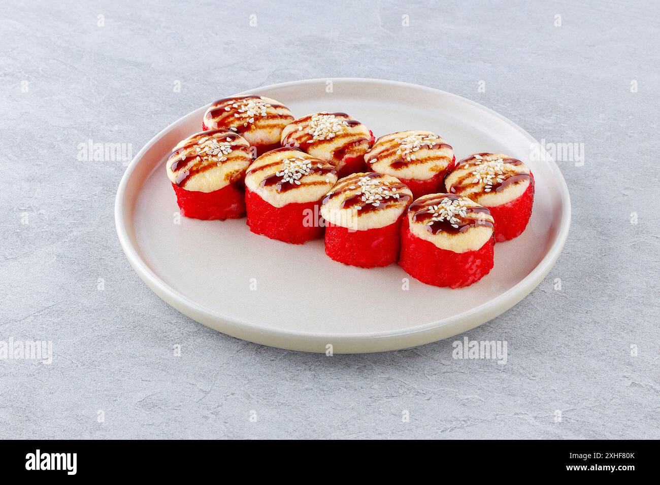 Sushi al forno con salmone in caviale, guarnito con salsa unagi e semi di sesamo Foto Stock