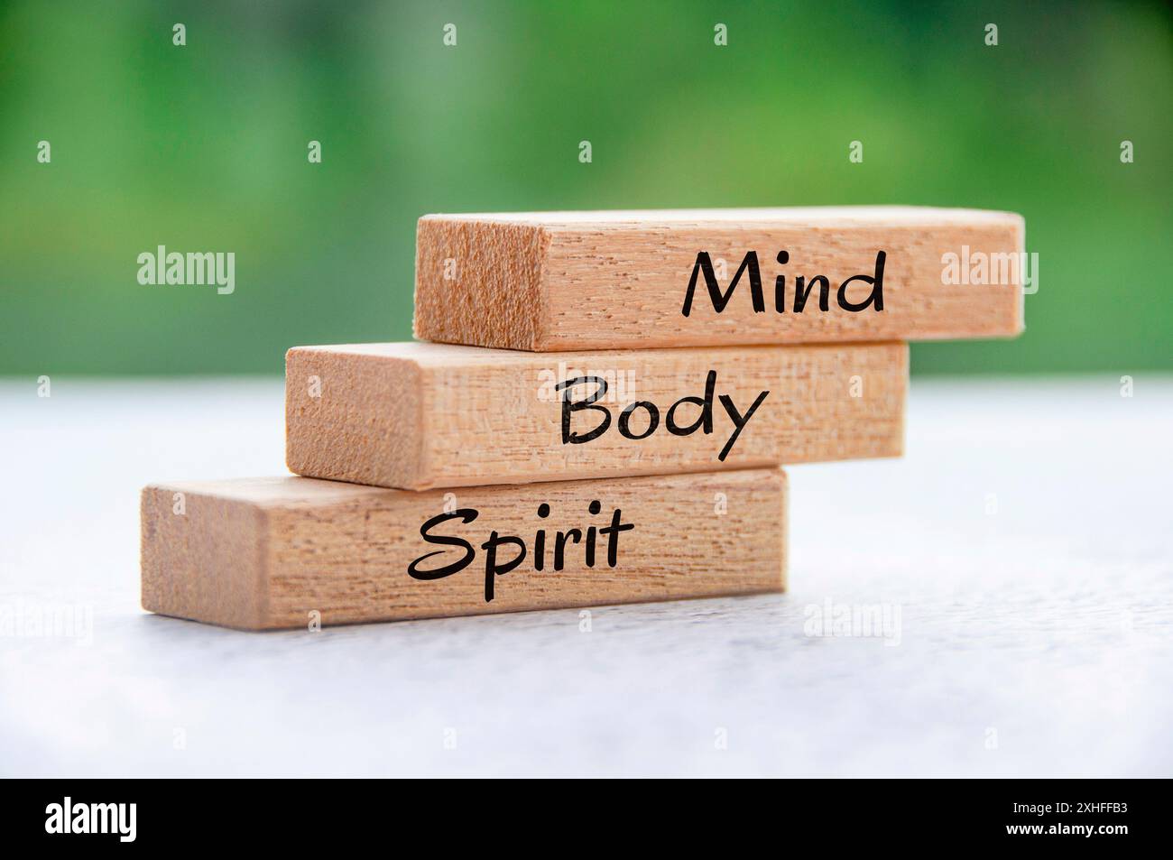 Mente, corpo e spirito su blocchi di legno con sfondo naturale. Foto Stock