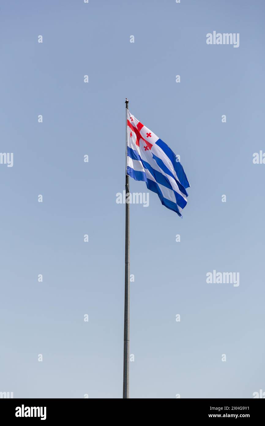 Adjara bandiera con croci rosse su bianco che sventolano contro il cielo azzurro, Adjara è una repubblica autonoma all'interno della Georgia. Foto Stock