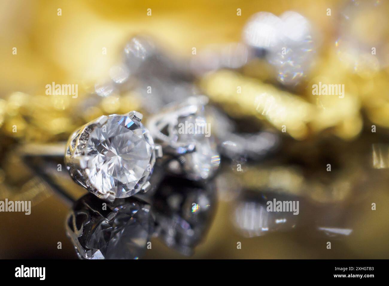 Orecchini diamantati gioielli in oro di lusso con riflesso su sfondo nero Foto Stock