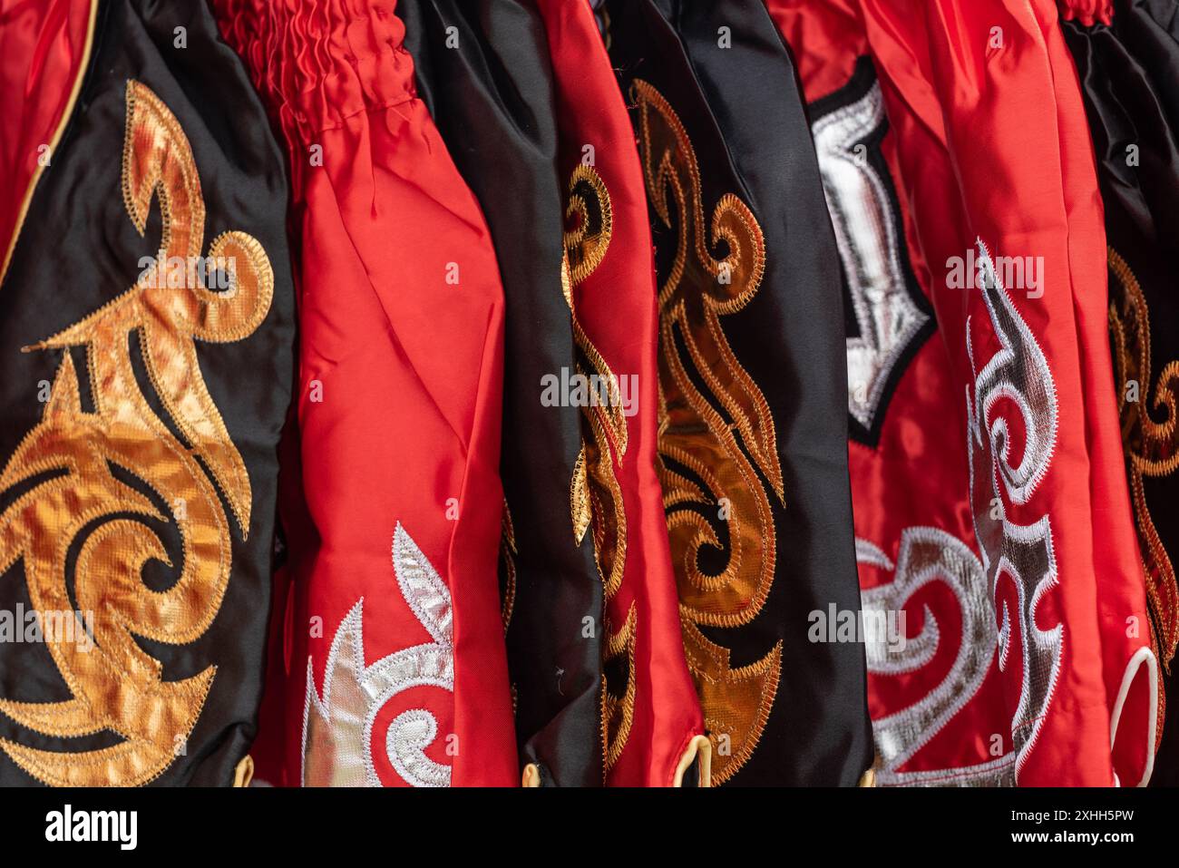 Immagine ravvicinata di vivaci e colorati motivi tessili dell'abbigliamento Muay Thai. Foto Stock