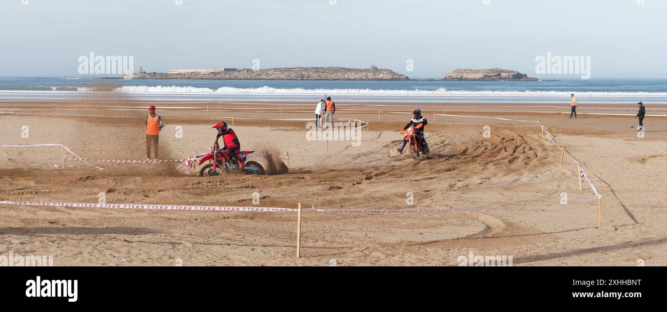 Gara di motocross sulla spiaggia con un'isola alle spalle all'orizzonte a Essaouira, Marocco. 13 gennaio 2024 Foto Stock