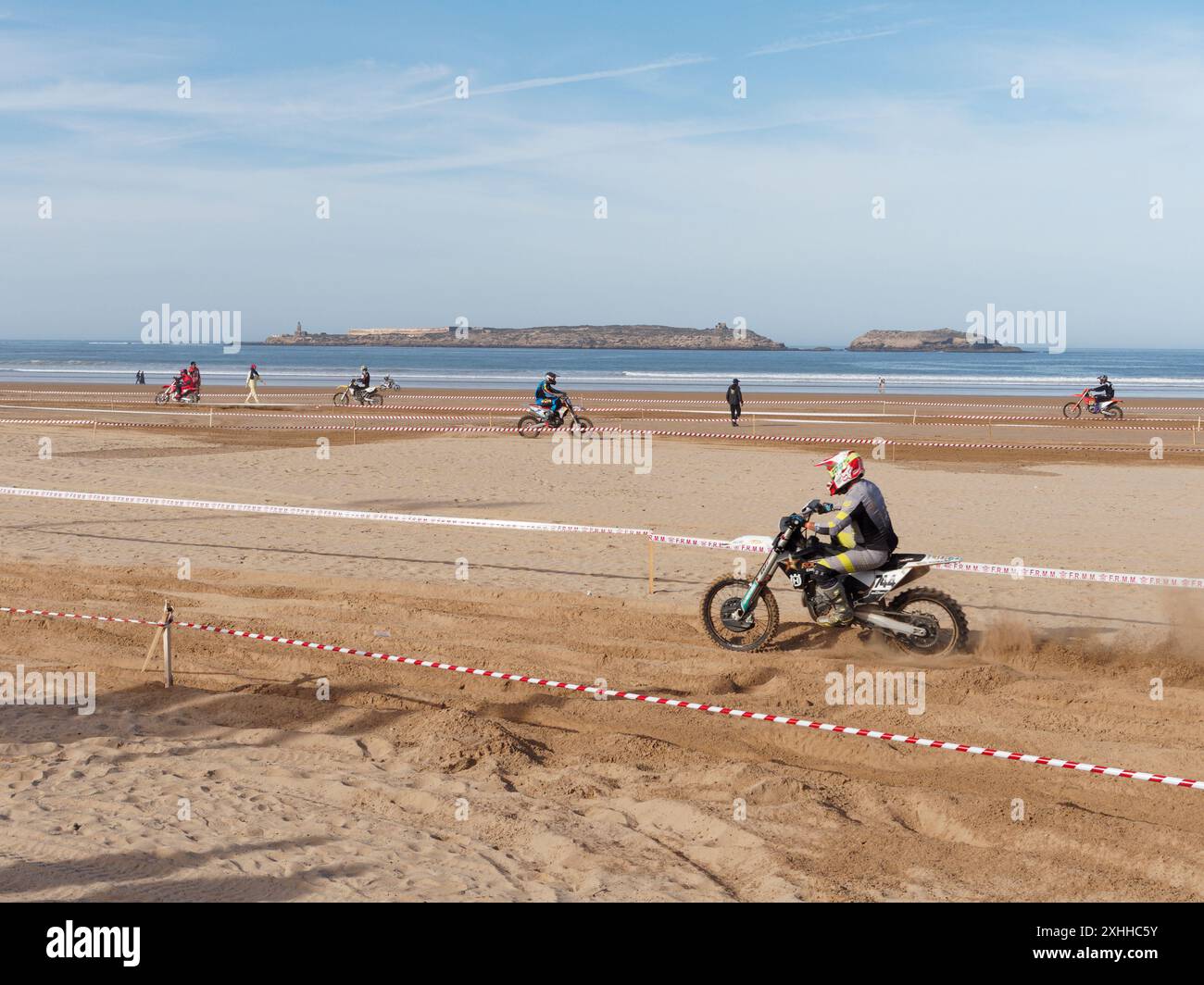 Gara di motocross sulla spiaggia con un'isola alle spalle all'orizzonte a Essaouira, Marocco. 13 gennaio 2024 Foto Stock