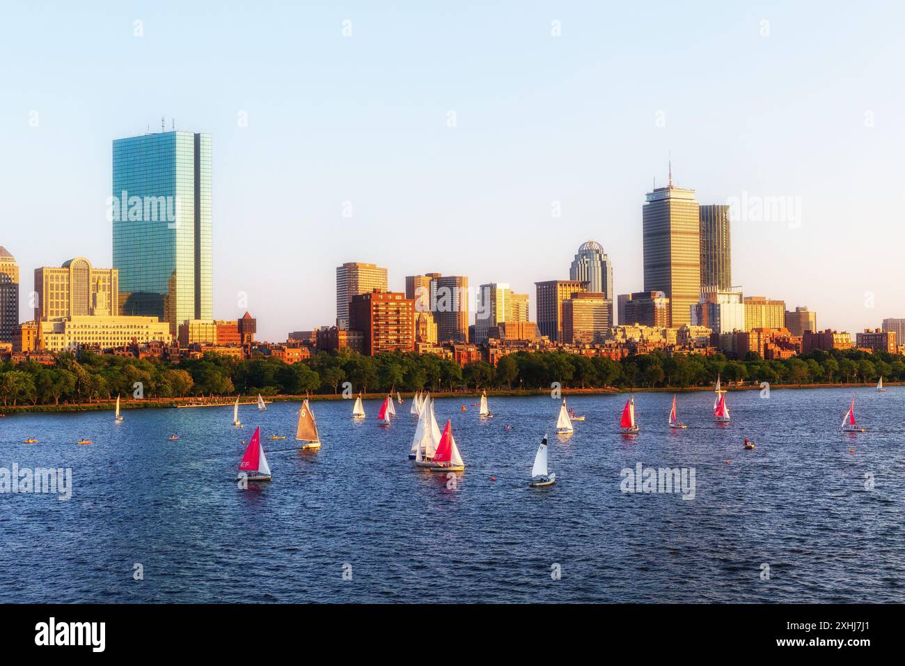 Tramonto sullo skyline di Boston Back Bay e sul fiume Charles con barche a vela. Foto Stock