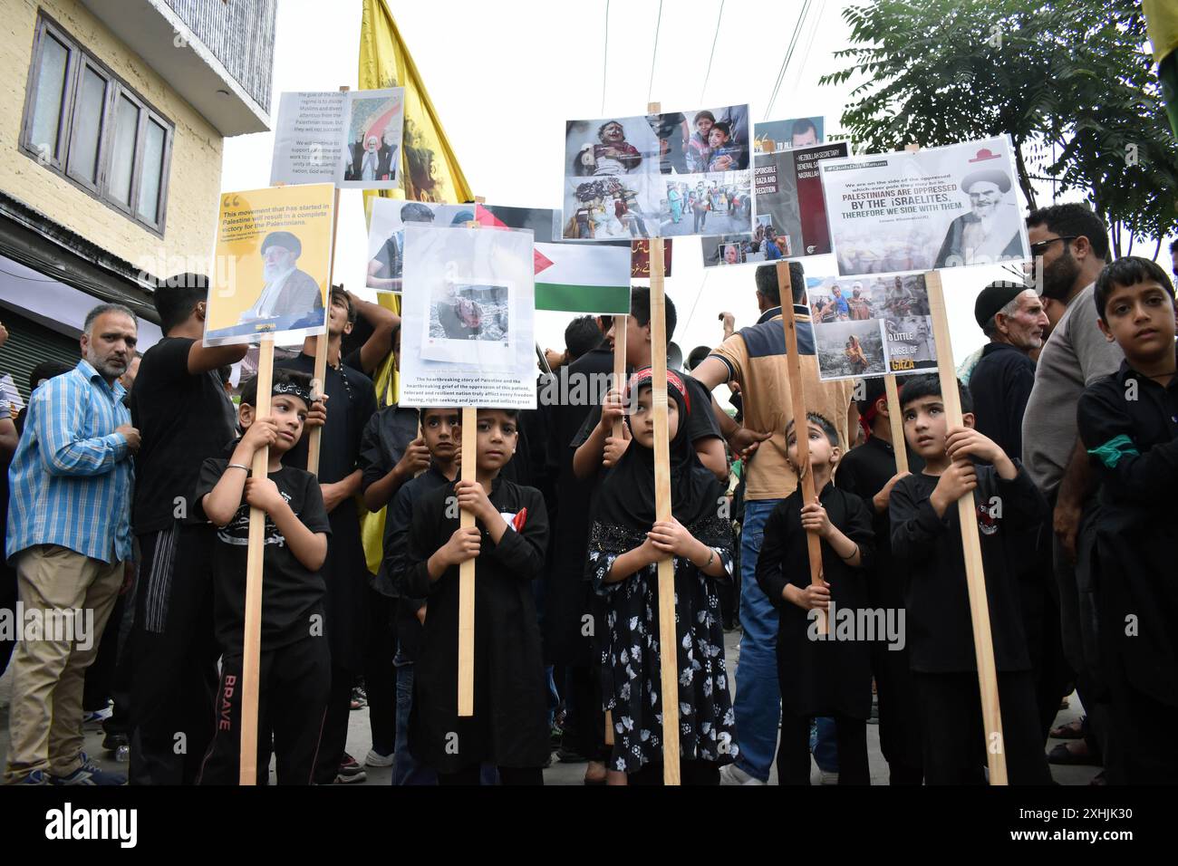 Srinagar, India. 14 luglio 2024. I ragazzi musulmani sciiti del Kashmir tengono bandiera palestinese e altri cartelli durante una processione di Muharram il settimo giorno di Muharram a Rainawari Srinagar il 14 luglio 2024. Muharram è il primo mese del calendario lunare islamico ed è considerato uno dei mesi più sacri dell'Islam. (Foto di Danish Showkat/Sipa USA) credito: SIPA USA/Alamy Live News Foto Stock