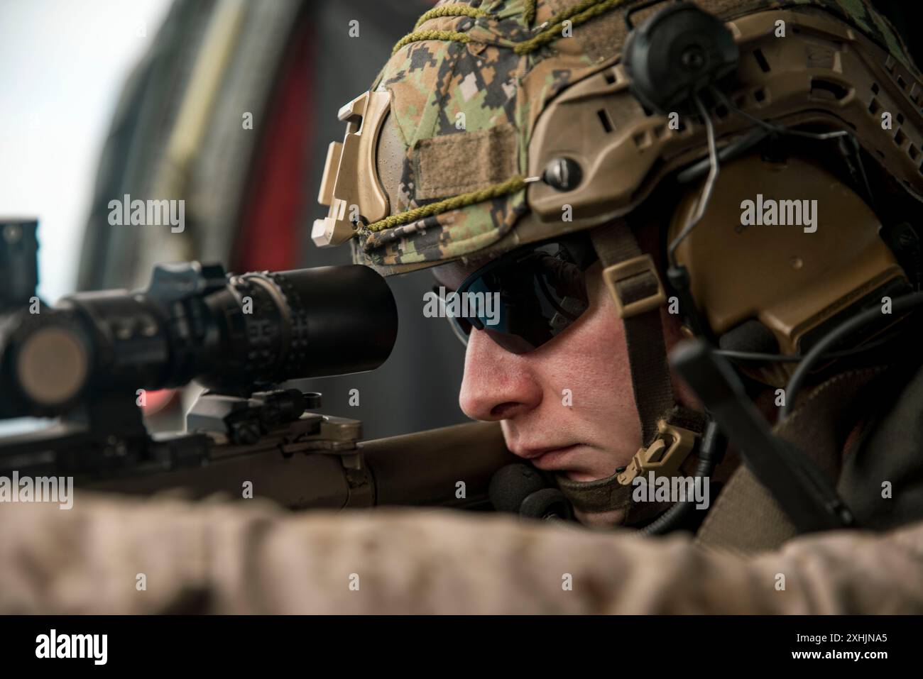 Noah Junge, capo della squadra di cecchini di ricognizione assegnato alla Weapons Company, Battalion Landing Team 1/5, 15th Marine Expeditionary Unit, e nativo del Missouri, ammira un M110 semi-Automatic Sniper System a bordo di un MH-60S Sea Hawk della marina statunitense, attaccato all'Helicopter Sea Combat Squadron (HSC) 23, durante l'addestramento di integrazione dei cecchini aerei sull'Oceano Pacifico il 12 luglio 2024. Elementi della 15a MEU sono attualmente imbarcati a bordo del Boxer Amphibious Ready Group che conduce operazioni di routine nella 3a flotta statunitense. (Foto del corpo dei Marines degli Stati Uniti del Cpl. Amelia Kang) Foto Stock