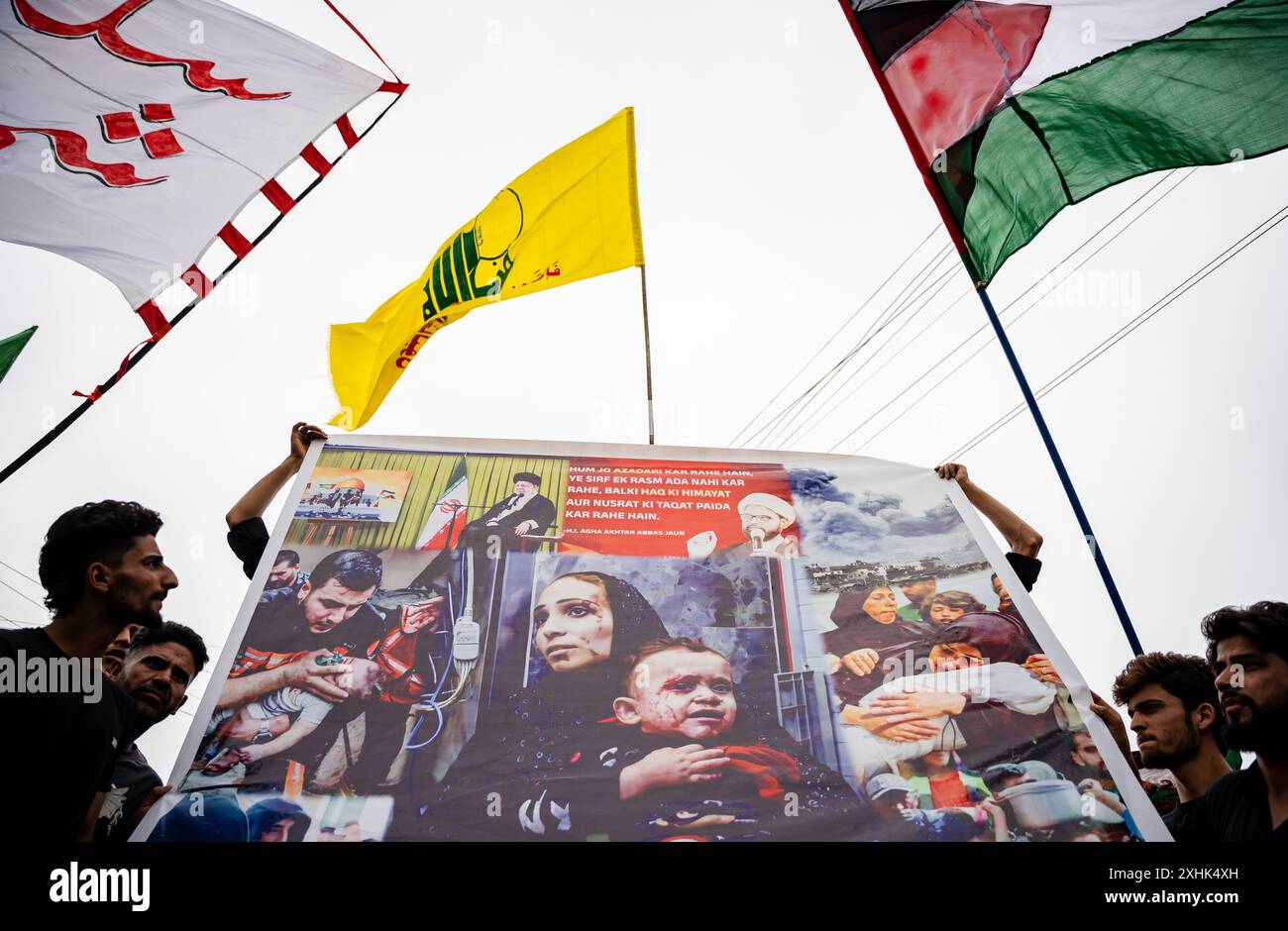 Uno striscione con fotografie di palestinesi, accanto a un Hezbollah e a una bandiera palestinese, si innalza sopra di esso durante una processione di Muharram il settimo giorno di Muharram. Muharram è il primo mese del calendario islamico. È uno dei mesi più sacri del calendario islamico. I musulmani sciiti commemorano Muharram come un mese di lutto in ricordo del martirio del profeta islamico Imam Hussain, nipote di Maometto, martirizzato su Ashura (10° giorno di Muharram) nella battaglia di Karbala nel 680 d.C. (foto di Idrees Abbas/SOPA Images/Sipa USA) Foto Stock