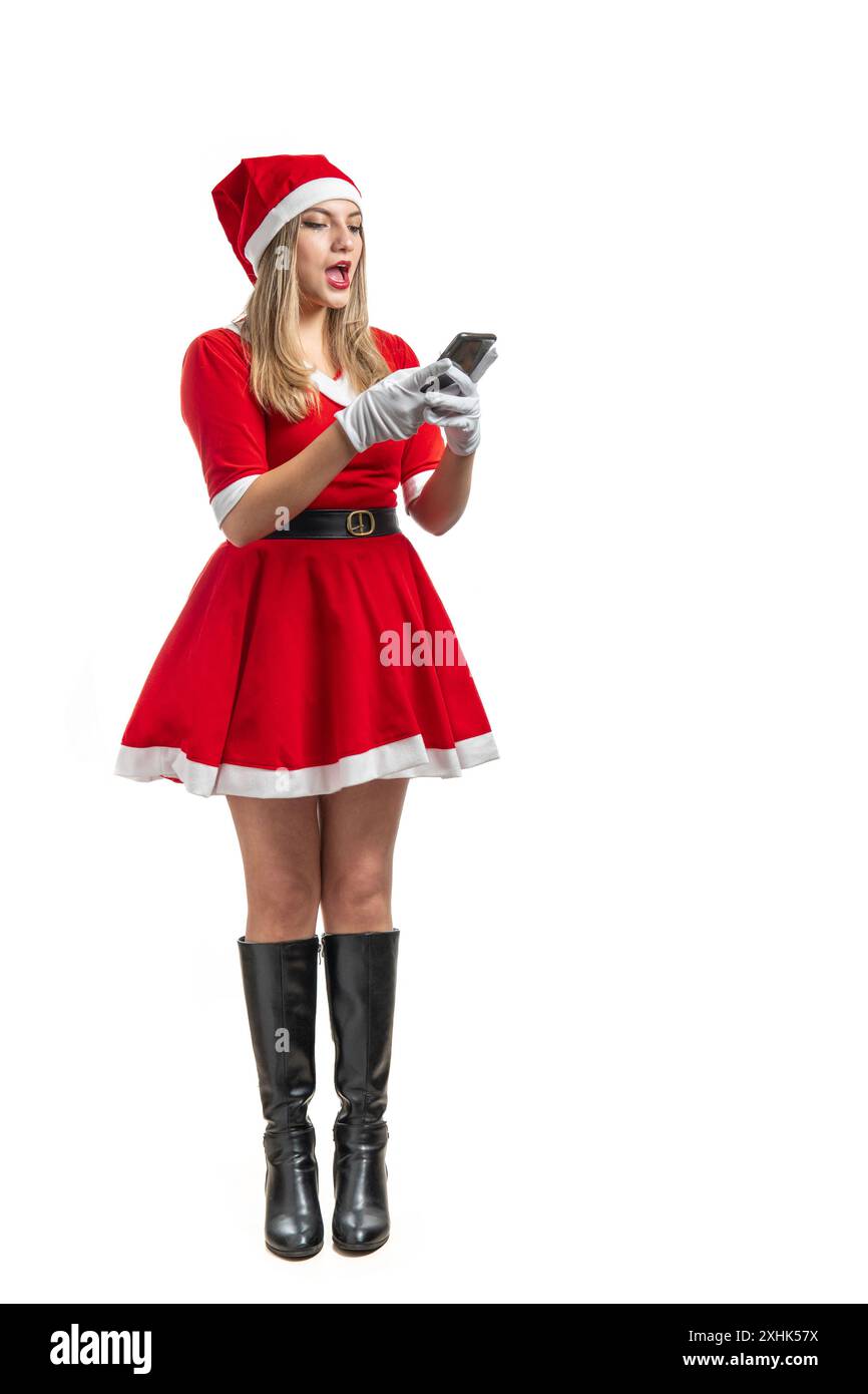 Una donna vestita da Babbo Natale ha sorpreso guardando un messaggio del cellulare isolato su sfondo bianco Foto Stock