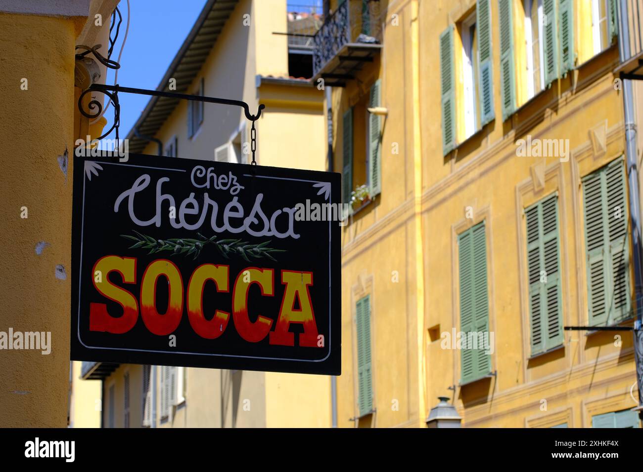 Durante la passeggiata nei pittoreschi vicoli della vecchia Nizza, è essenziale gustare una parte di socca, una famosa torta di farina di ceci, un must. Foto Stock
