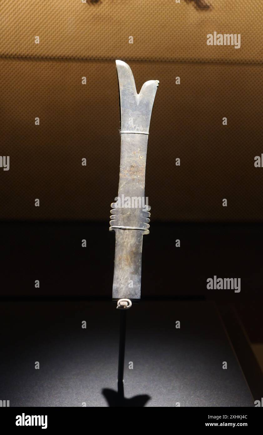 Guanghan Cina - 24 maggio 2024: Una lama Yazhang di giada datata alla dinastia Shang è esposta al Museo Sanxingdui, provincia del Sichuan in Cina. Foto Stock