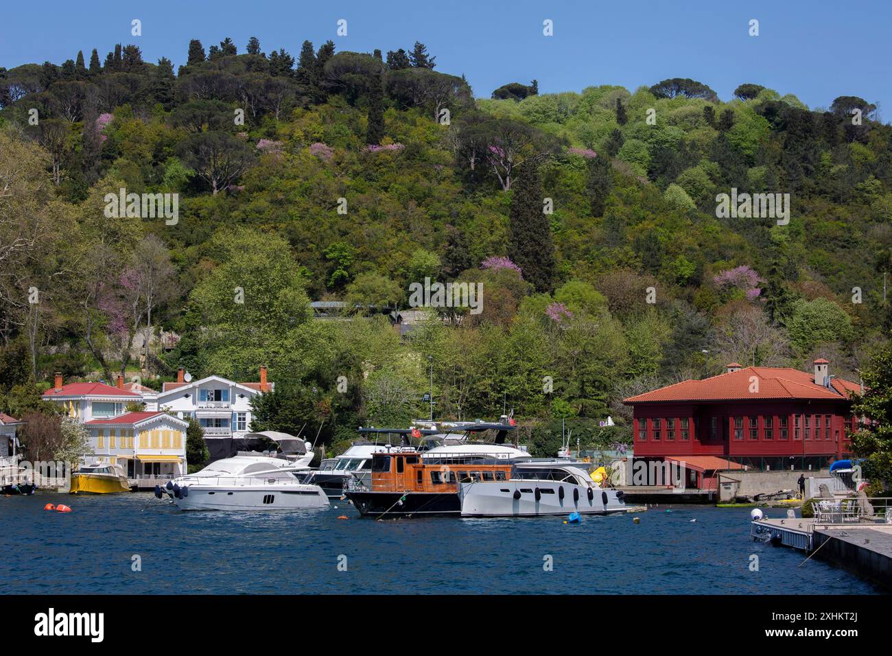 Turchia, Istanbul, case in legno ottomane e piccole imbarcazioni da diporto poste sul bordo dell'acqua e ai piedi di una collina boscosa sul lato asiatico del Foto Stock