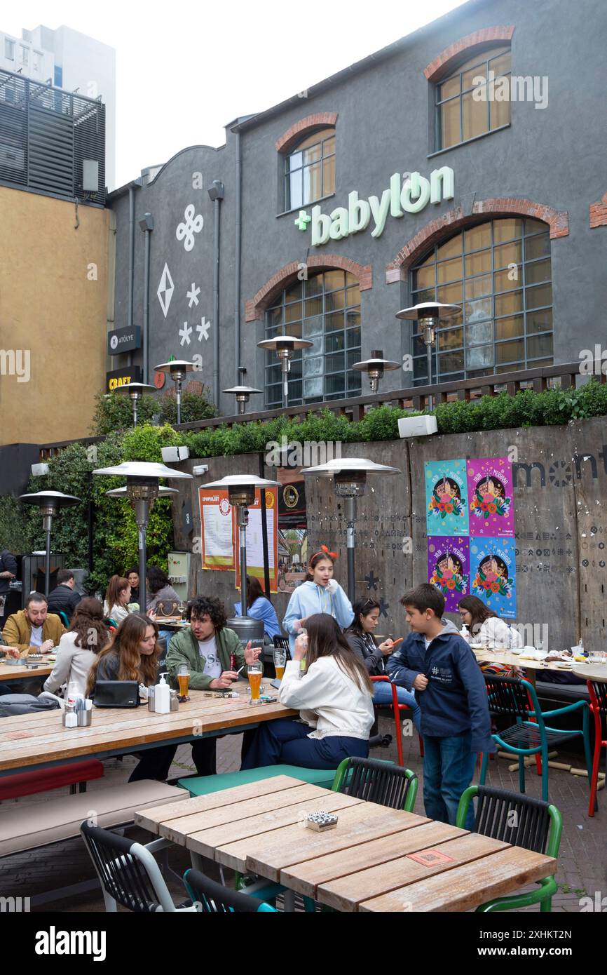 Turchia, Istanbul, Bomontiada, giovani seduti in una terrazza caffetteria alla moda nell'ambiente industriale di Bomonti, un complesso artistico che occupa una forma Foto Stock