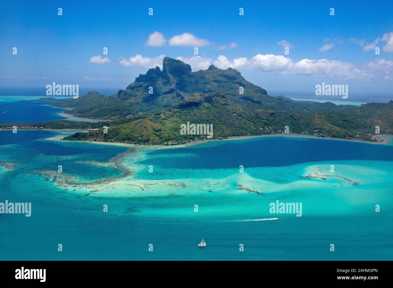 Polinesia francese, isola di Bora Bora, massiccio vulcanico circondato da una laguna turchese (vista aerea) Foto Stock