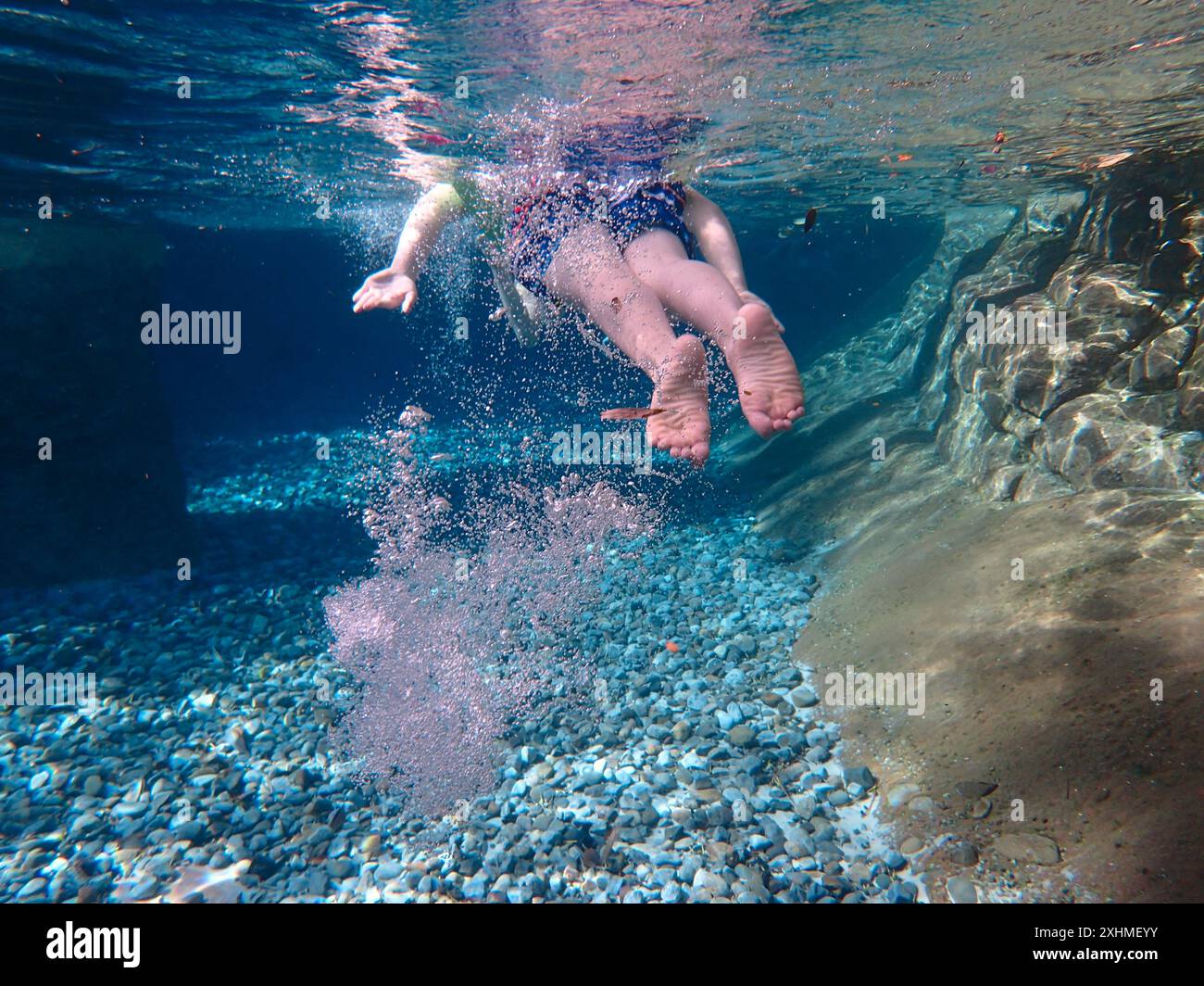 Teen Boy che nuota nell'oceano con le bolle Foto Stock