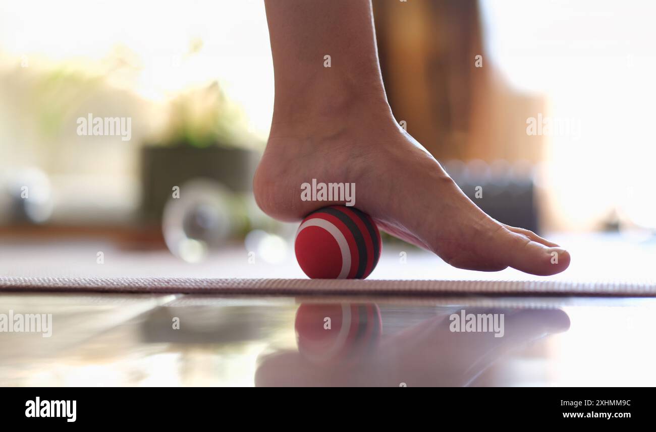 Primo piano del rilascio miofasciale dei muscoli ipermobili del piede con palla da massaggio. Prevenzione dell'affaticamento delle gambe e del concetto di malattia del piede Foto Stock