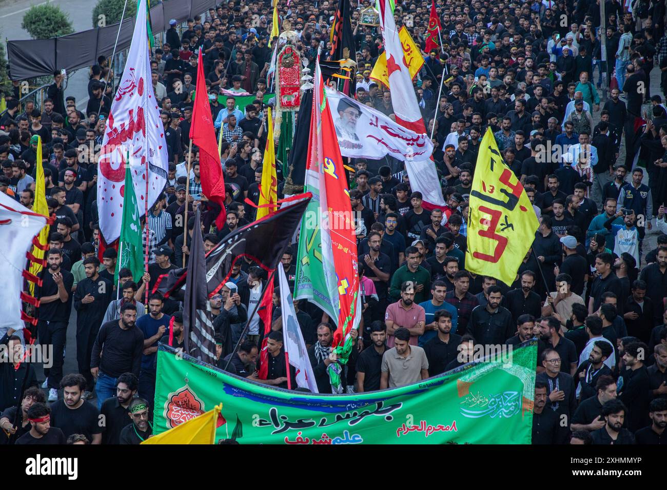 I musulmani sciiti kashmiri detengono bandiere religiose mentre prendono parte all'ottavo giorno della processione di Muharram nel centro della città di Srinagar. In una stretta sicurezza, per il secondo anno consecutivo dopo oltre tre decenni, le autorità indiane permisero all'ottava processione di Muharram di passare attraverso il suo percorso tradizionale nella capitale del Kashmir, Srinagar, dal momento che fu bandita nel 1989, quando iniziò una ribellione popolare contro il dominio di nuova Delhi nella regione contesa dell'Himalaya. I musulmani sciiti di tutto il mondo commemorano Muharram, il primo e più santo mese del calendario islamico, come mese di lutto a reme Foto Stock