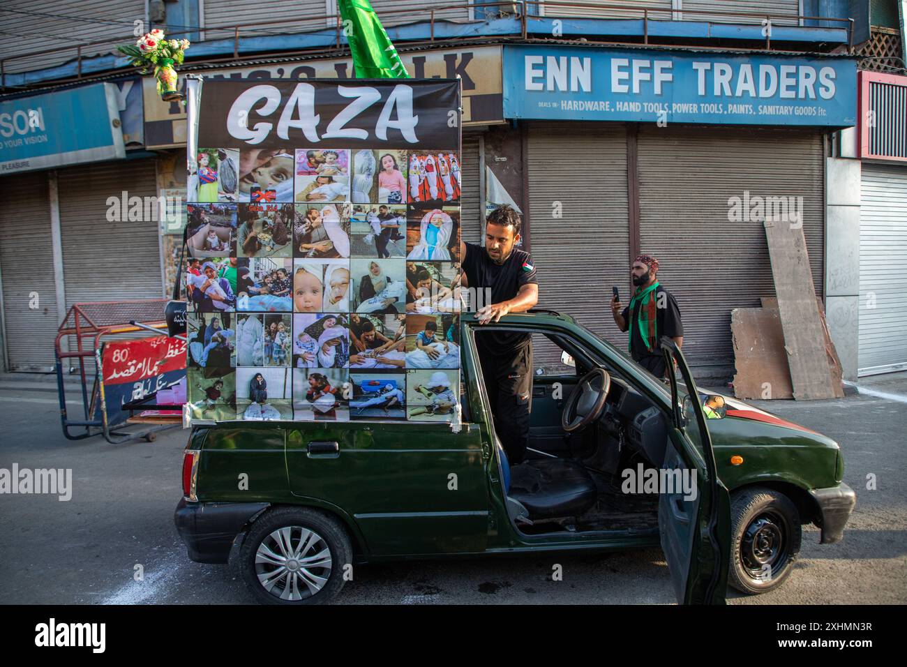 Un poster mostra i bambini palestinesi uccisi incollati su un'auto mentre i musulmani sciiti kashmiri prendono parte all'ottavo giorno della processione di Muharram nel centro della città di Srinagar. In una stretta sicurezza, per il secondo anno consecutivo dopo oltre tre decenni, le autorità indiane permisero all'ottava processione di Muharram di passare attraverso il suo percorso tradizionale nella capitale del Kashmir, Srinagar, dal momento che fu bandita nel 1989, quando iniziò una ribellione popolare contro il dominio di nuova Delhi nella regione contesa dell'Himalaya. I musulmani sciiti di tutto il mondo commemorano Muharram, il primo e più santo mese della cale islamica Foto Stock