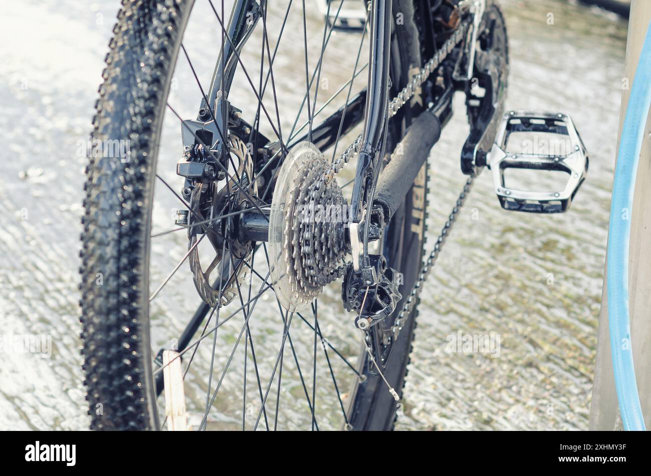 Parte della bicicletta dopo il lavaggio in autolavaggio. Pulire la ruota bagnata con razze, catena e pedale. Attività Foto Stock