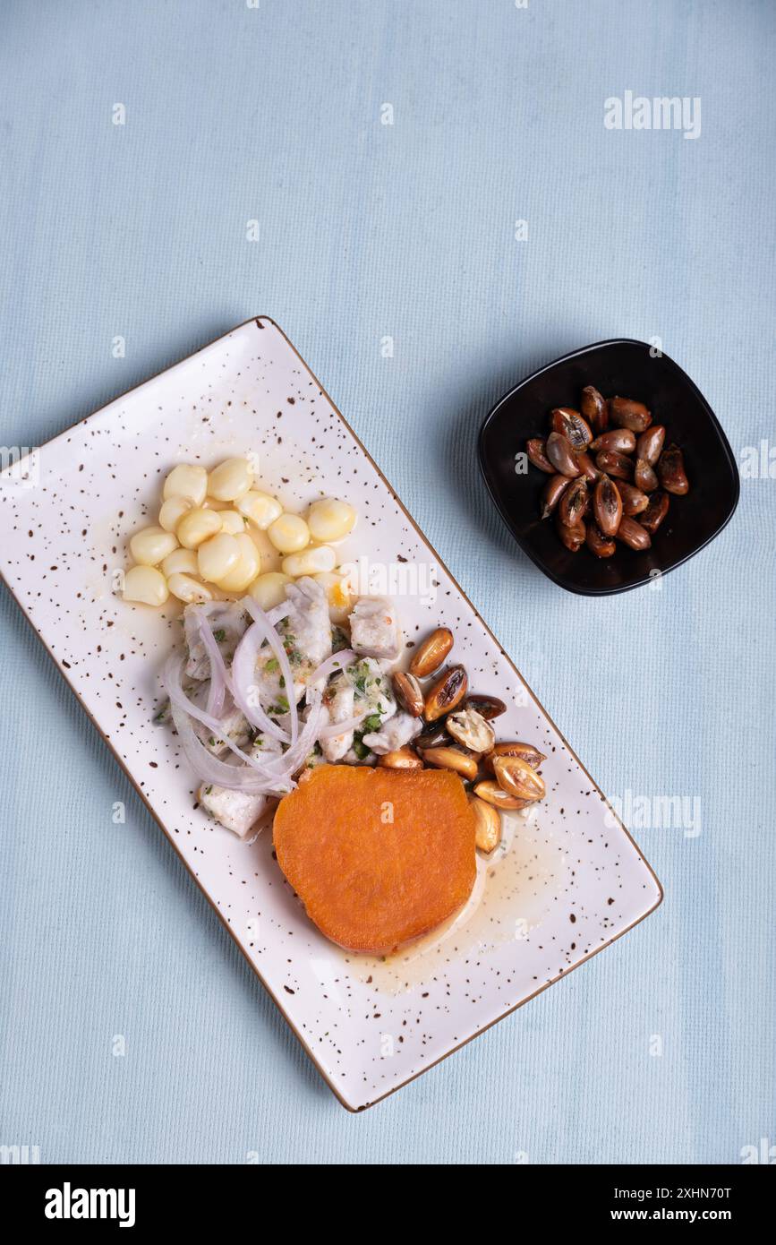 Vista dall'alto di un piatto rappresentativo della gastronomia peruviana con una porzione di mais arrosto. Foto Stock