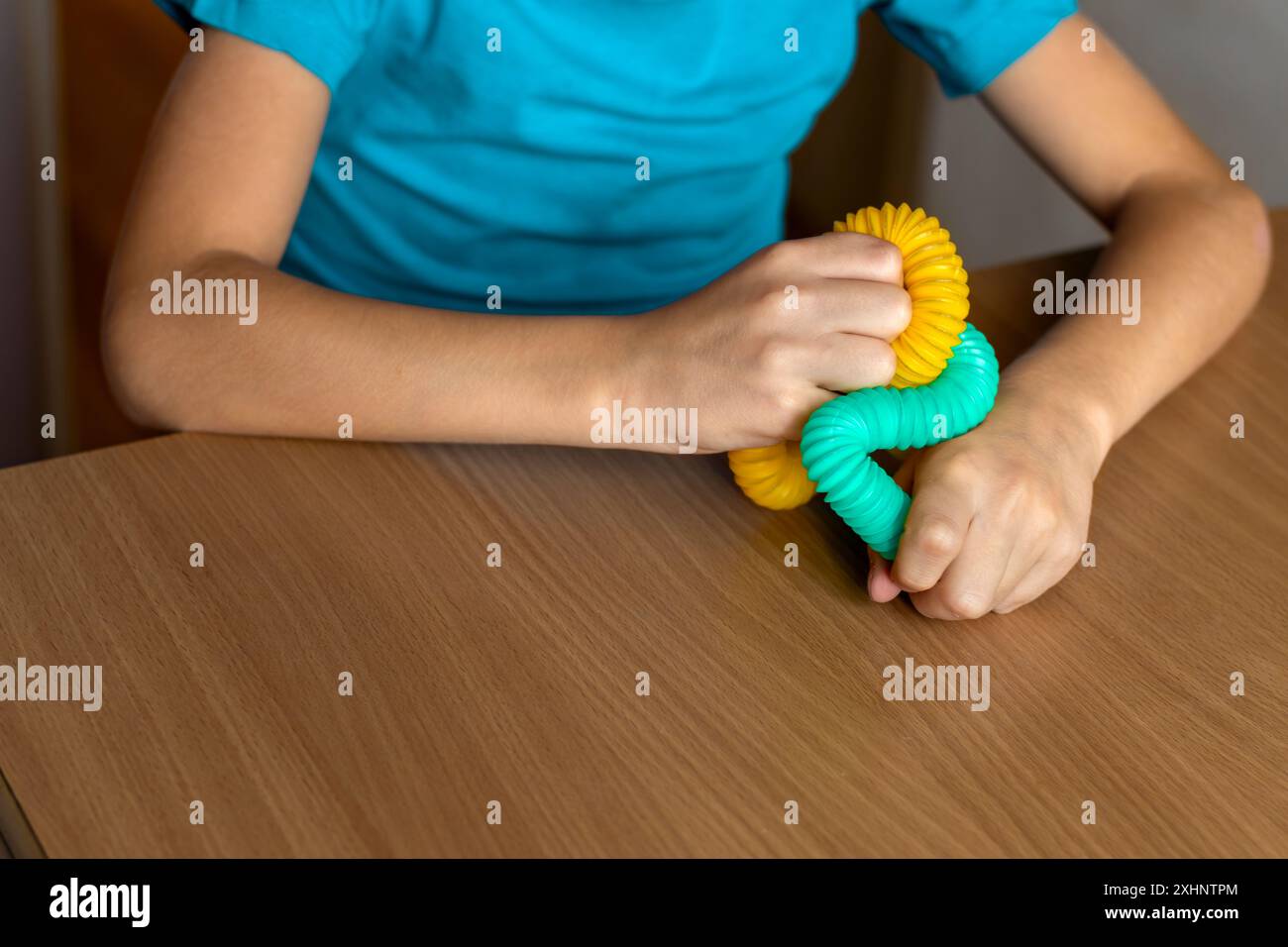 Giocattoli multicolori anti-stress con tubo a pressione per bambini. Tubo flessibile ondulato nelle mani dei bambini. primo piano. Prendersi cura della salute mentale. Foto Stock