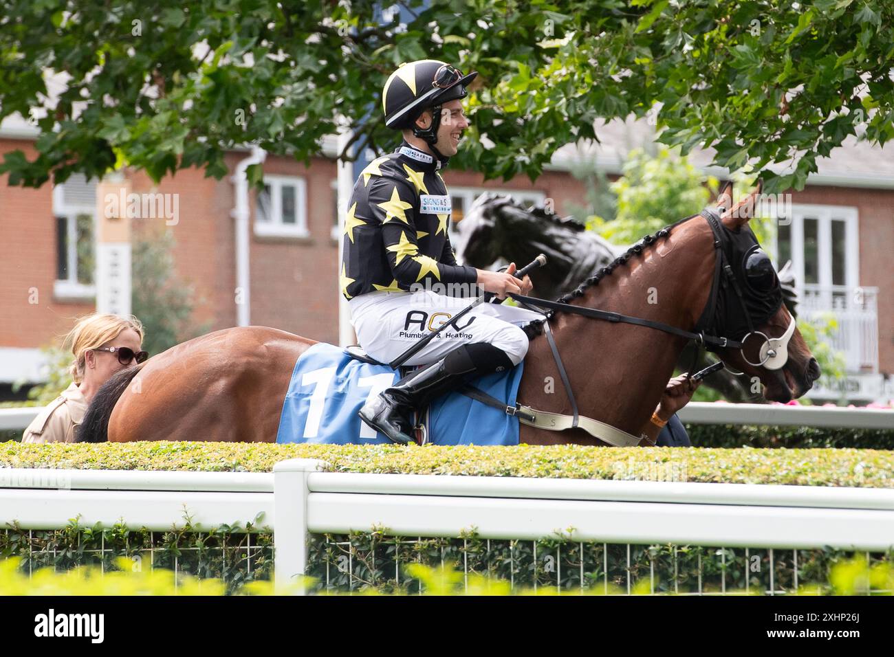 Ascot, Berkshire, Regno Unito. 13 luglio 2024. Horse Woolhampton, cavalcato dal fantino Oliver Searle, si dirige verso l'ippodromo per gareggiare nella A1R Services Heritage handicap Stakes presso l'ippodromo di Ascot nel Berkshire, durante il Summer Mile Family Raceday. Proprietario David Klein, allenatore Rod Millman, Cullompton, allevatore Cavalier Bloodstock & James Lombard, Sponsor Signs & Safety Ltd, Millman Racing Club, Rod Millman Racing Ltd Crediti: Maureen McLean/Alamy Foto Stock