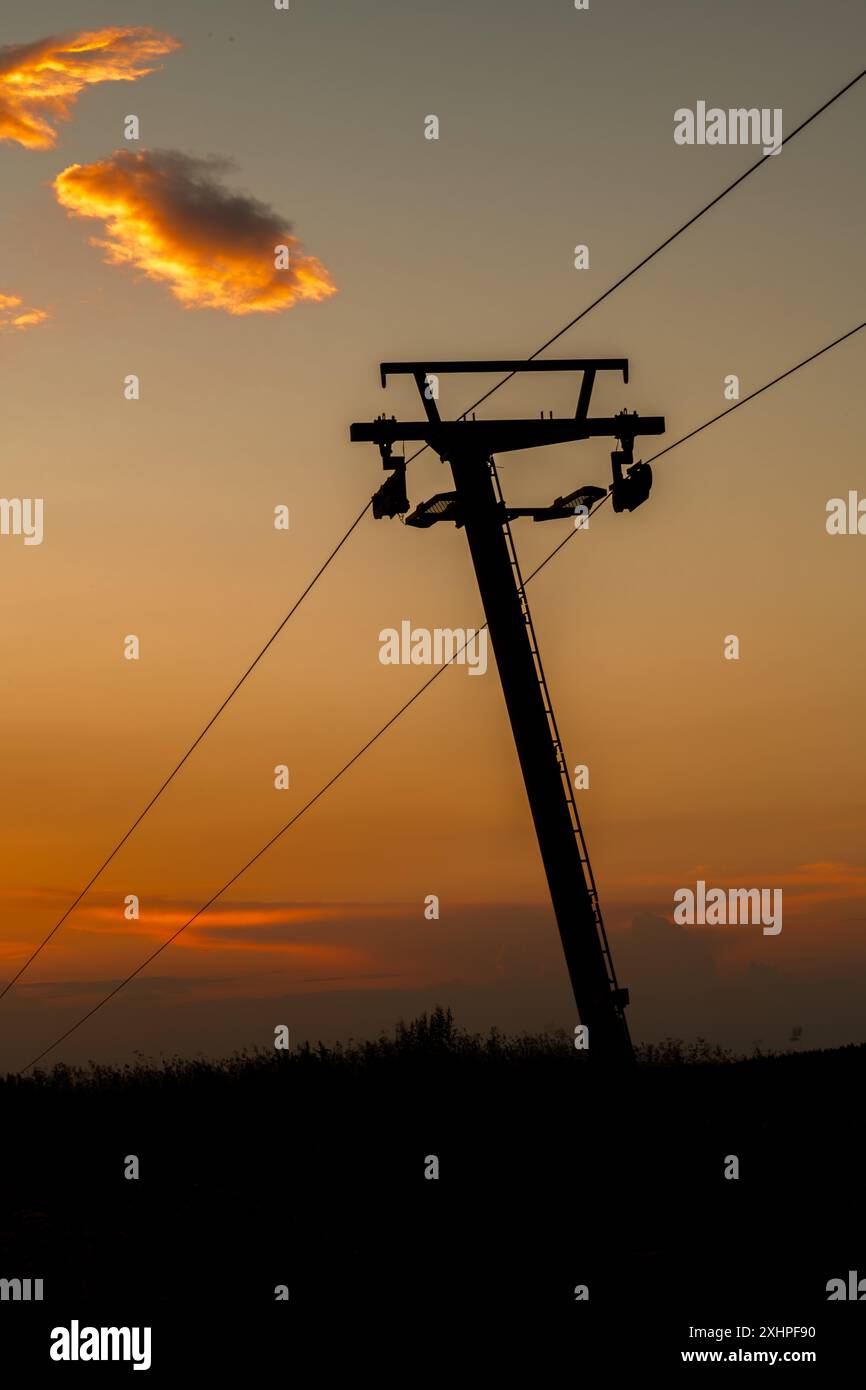 Sagoma di palo da sci con fili e colore del tramonto Foto Stock