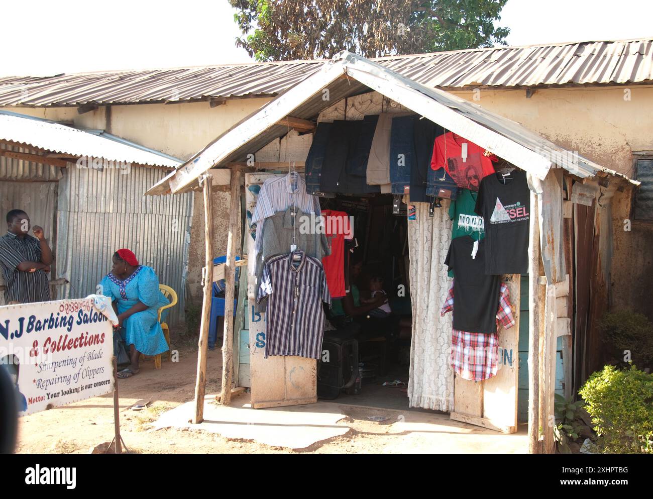 Bancarelle a lato della strada, Jos, Plateau State, Nigeria - bancarelle di vestiti, uomo e donna che chiacchierano Foto Stock