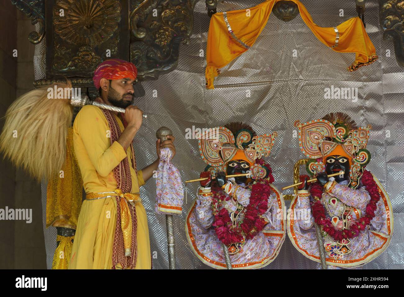 India, Uttar Pradesh, Holi festival, servitore del tempio con flywhisk davanti ai due idoli di Krishna e Radha Foto Stock
